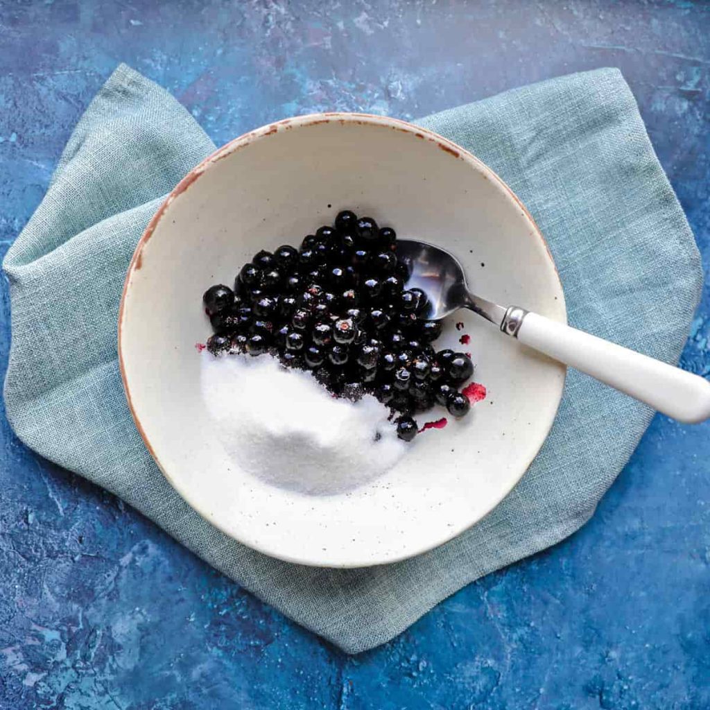 Bowl with blackcurrants and sugar