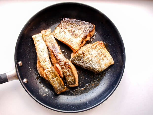 Skin side up salmon in pan