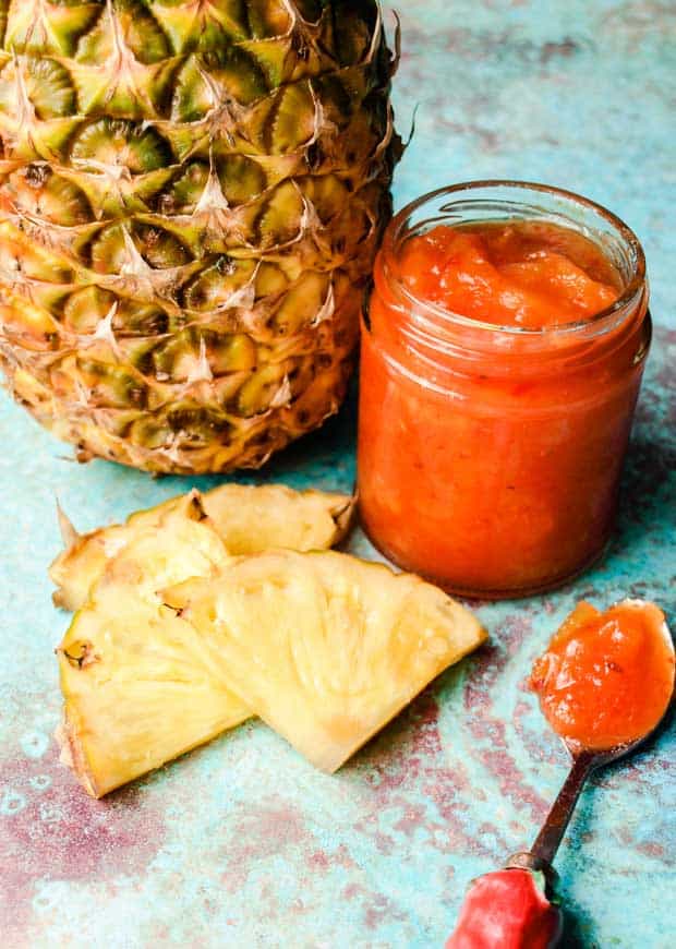 Pineapple and slices of pineapple with jar of pineapple chilli jam 