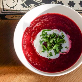 Serve Beetroot and Black Cumin Soup with garlic yogurt and parsley
