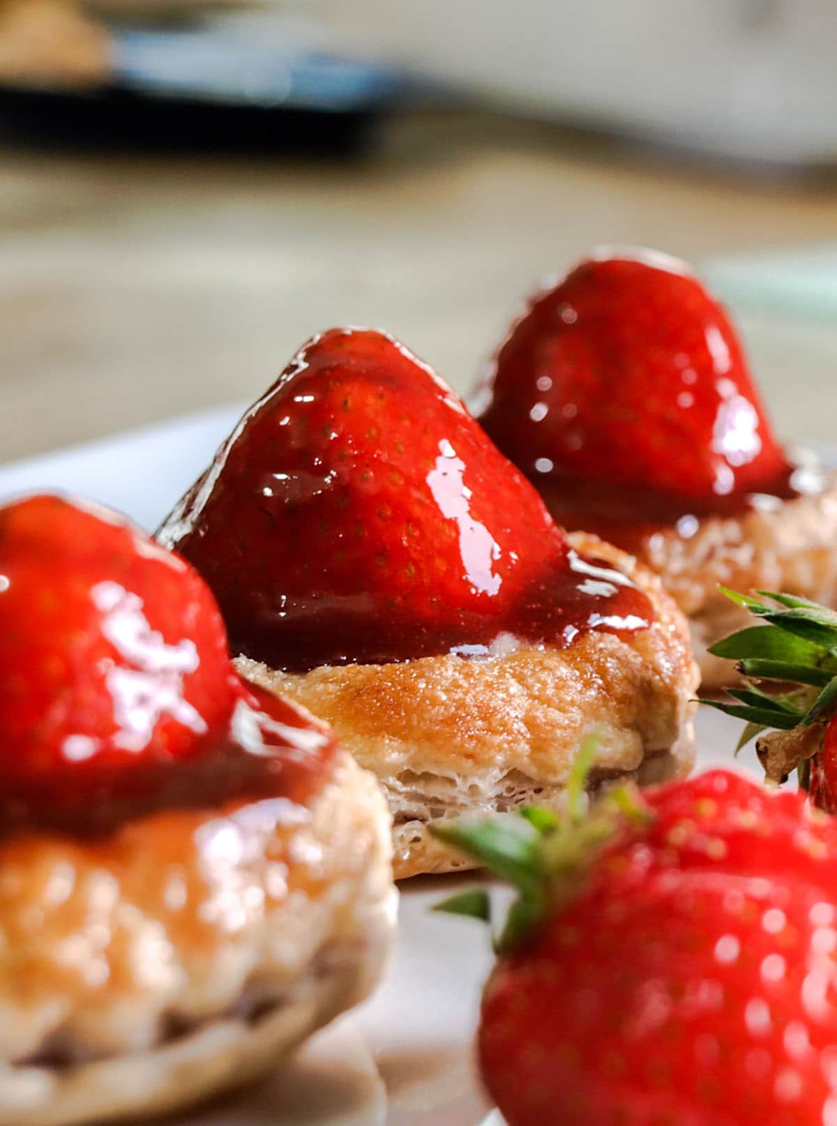 3 Puff Pastry Strawberry Tarts on plate with strawberry