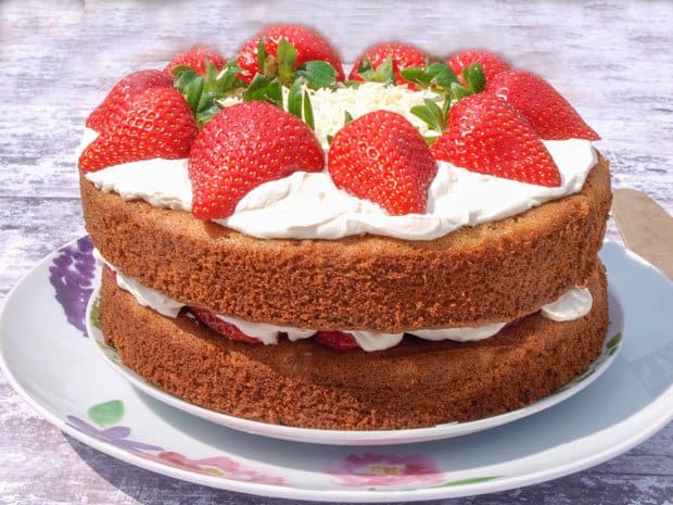 Layers of white chocolate cake filled with strawberries and cream