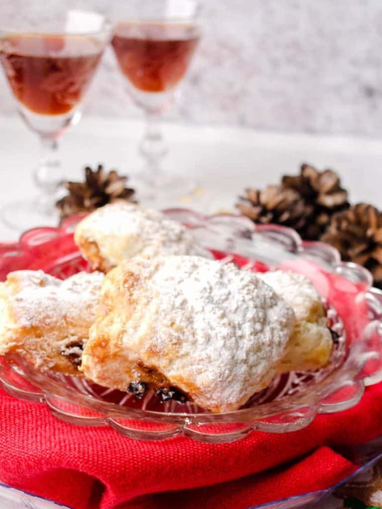 Puff Pastry Mincemeat rolls on plate with two glasses of sherry