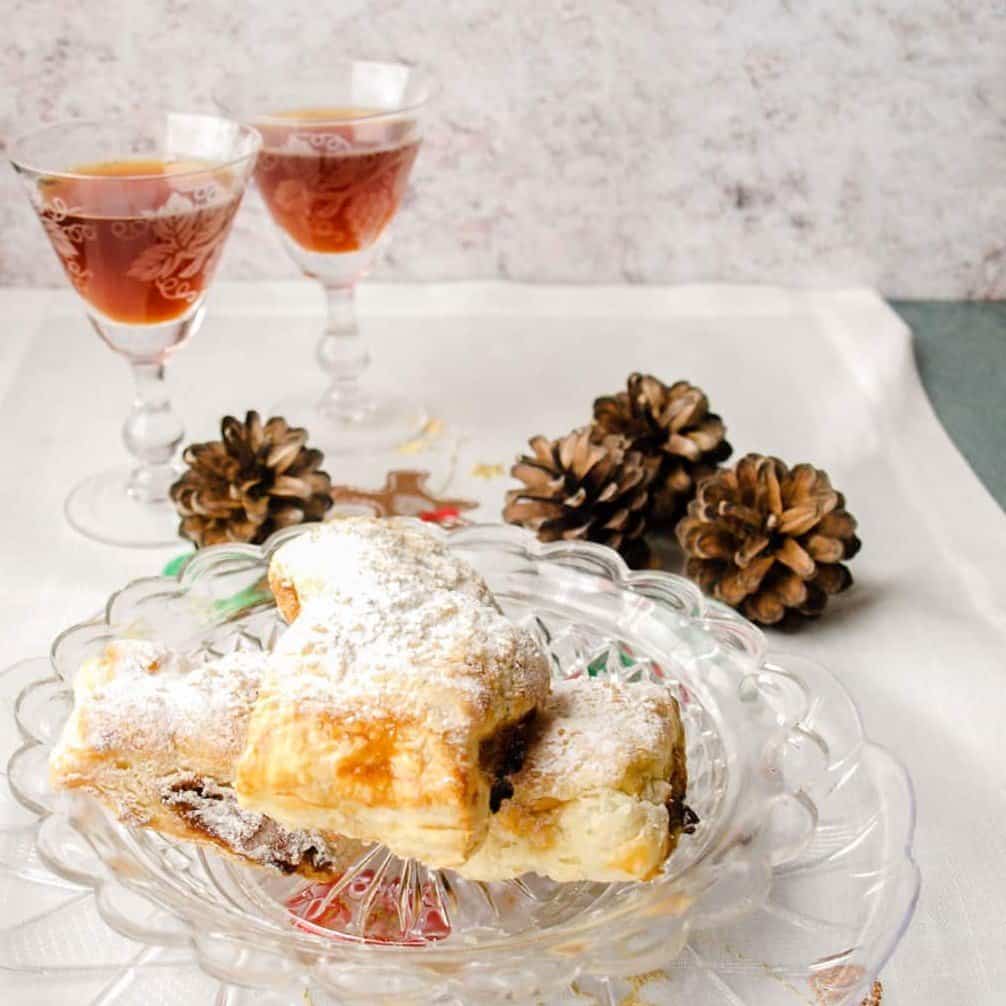 Mincemeat Rolls on plate with glasses of sherry and pine cones