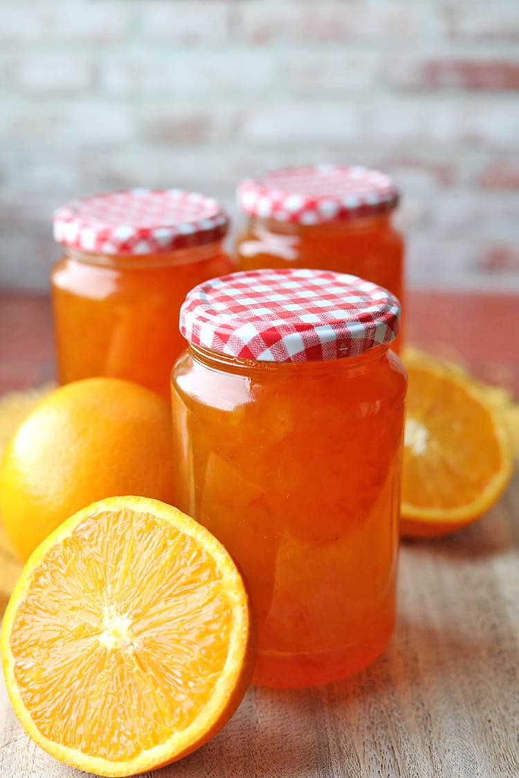 jar of seville orange marmalade and oranges.