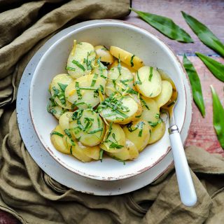 New potatoes with wild garlic & lemon in bowl with spoon