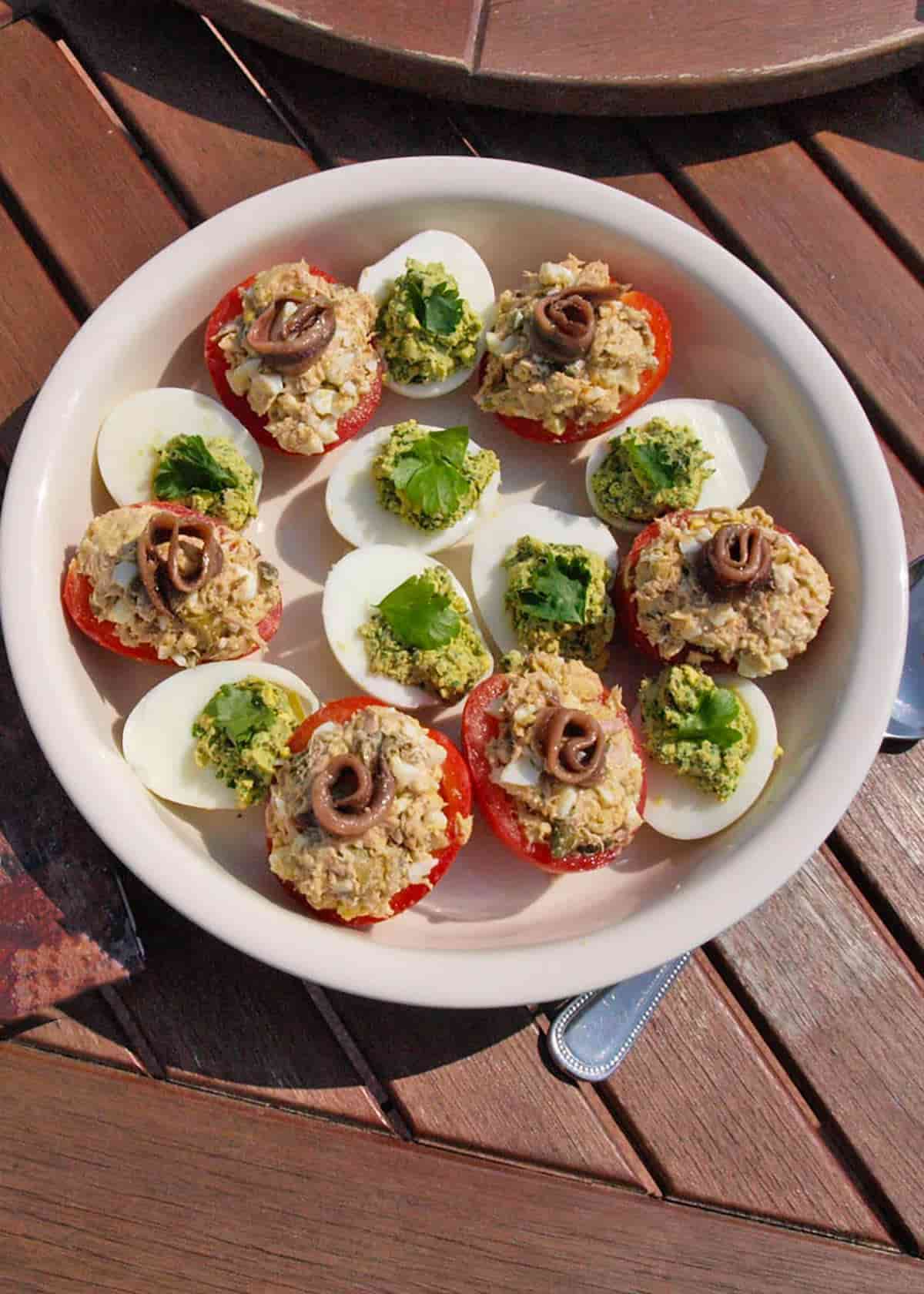 plate of stuffed tomatoes with stuffed eggs