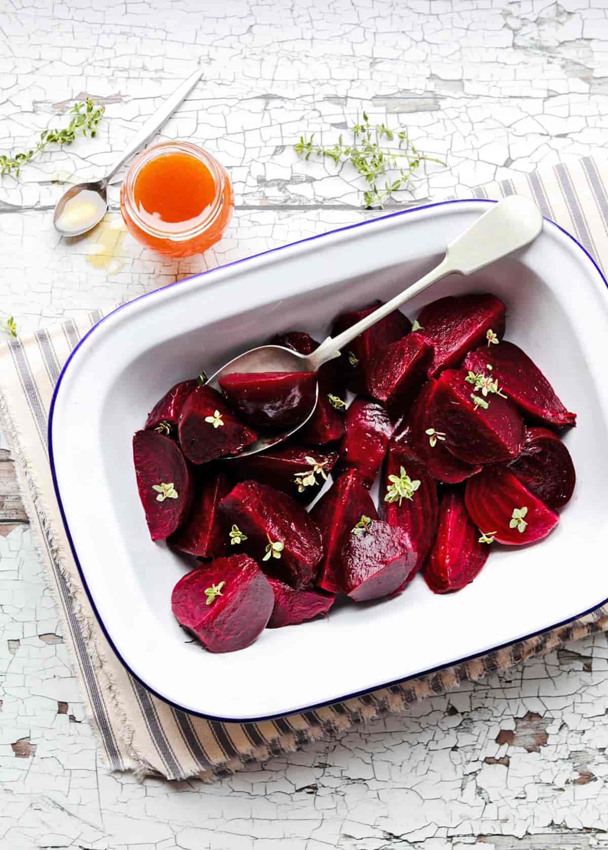 Roast Beetroot with Honey & Thyme in pie dish with spoon and honey jar
