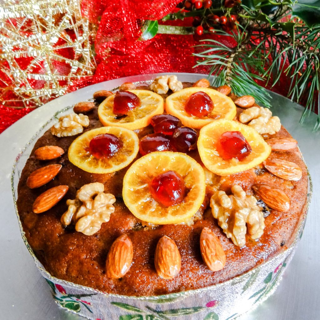Last Minute Christmas Cake topped with orange slices, cherries, almonds and walnuts