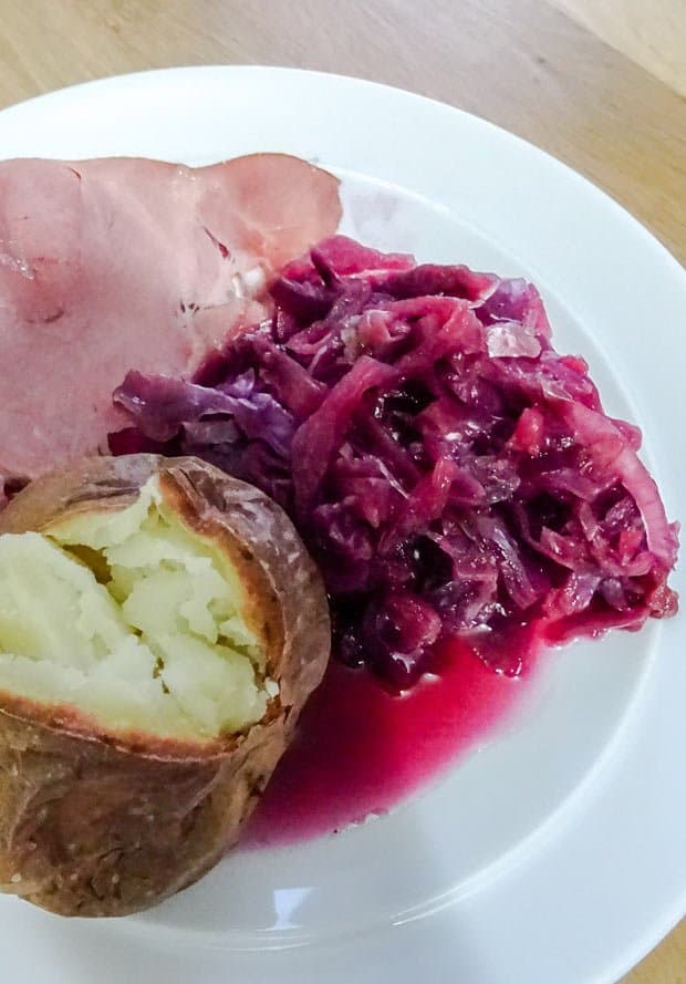 Plate with red cabbage, baked potato and ham