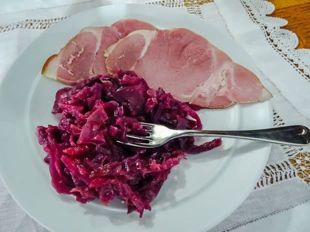 plate of red cabbage, ham and fork.