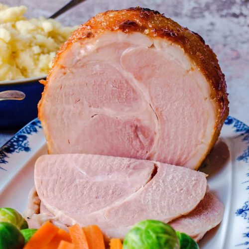 Ham Sliced with vegetables on platter.