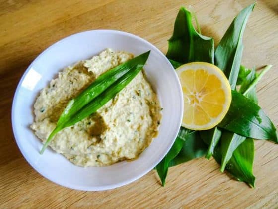 Wild Garlic Hummus in a pot with leaves and lemon