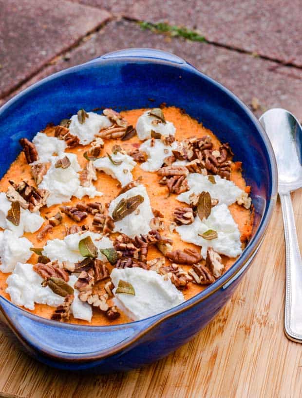 Blue serving dish of Sweet Potato Mash with pecans and ricotta.