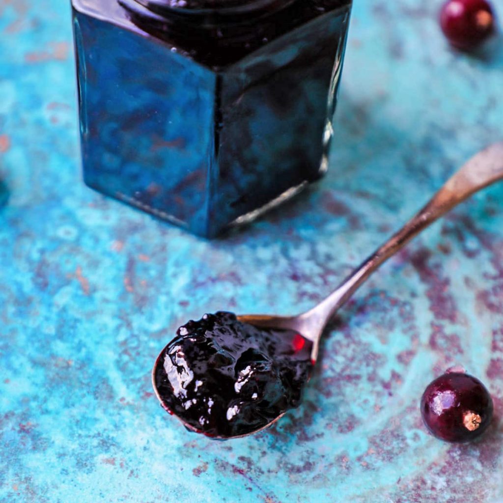 Spoon of blackcurrant jam with blackcurrants