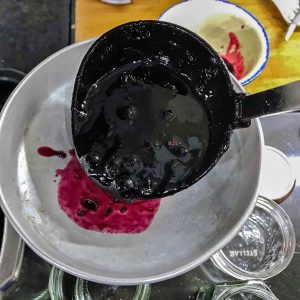 Blackcurrant jam laded into jam funnel