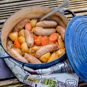 Cider, Apple and Sausage Casserole with spoon and lid