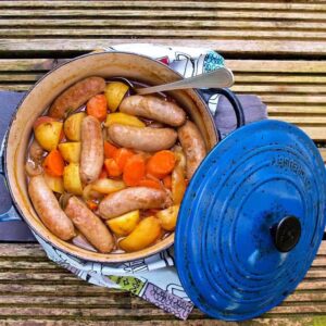 cider, apple and sausage casserole with lid on side of casserole.