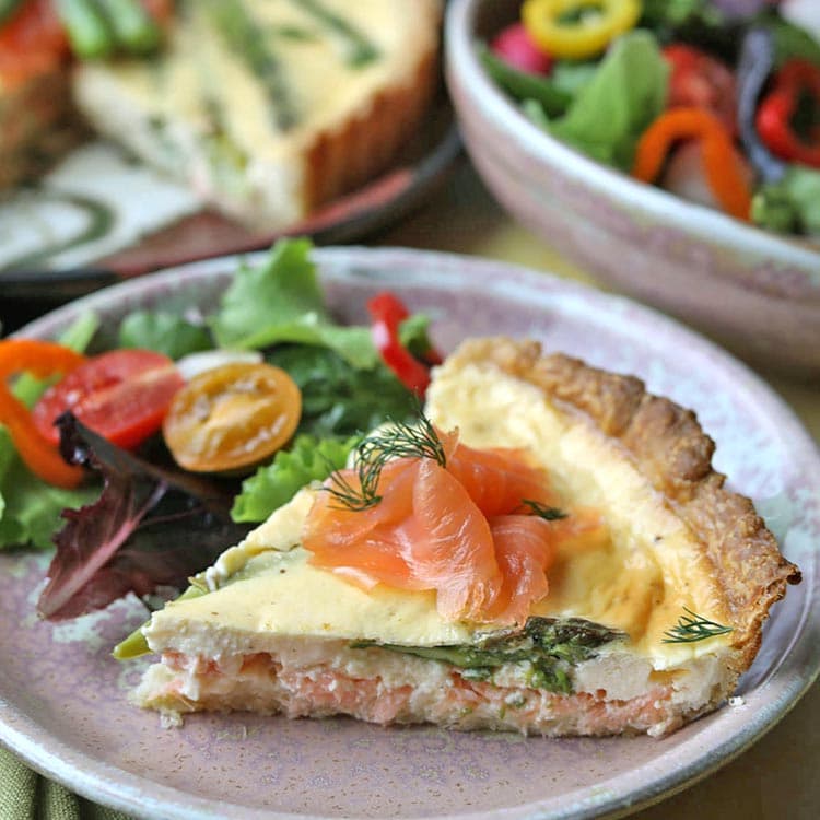 slice of smoked salmon and asparagus tart with salad.