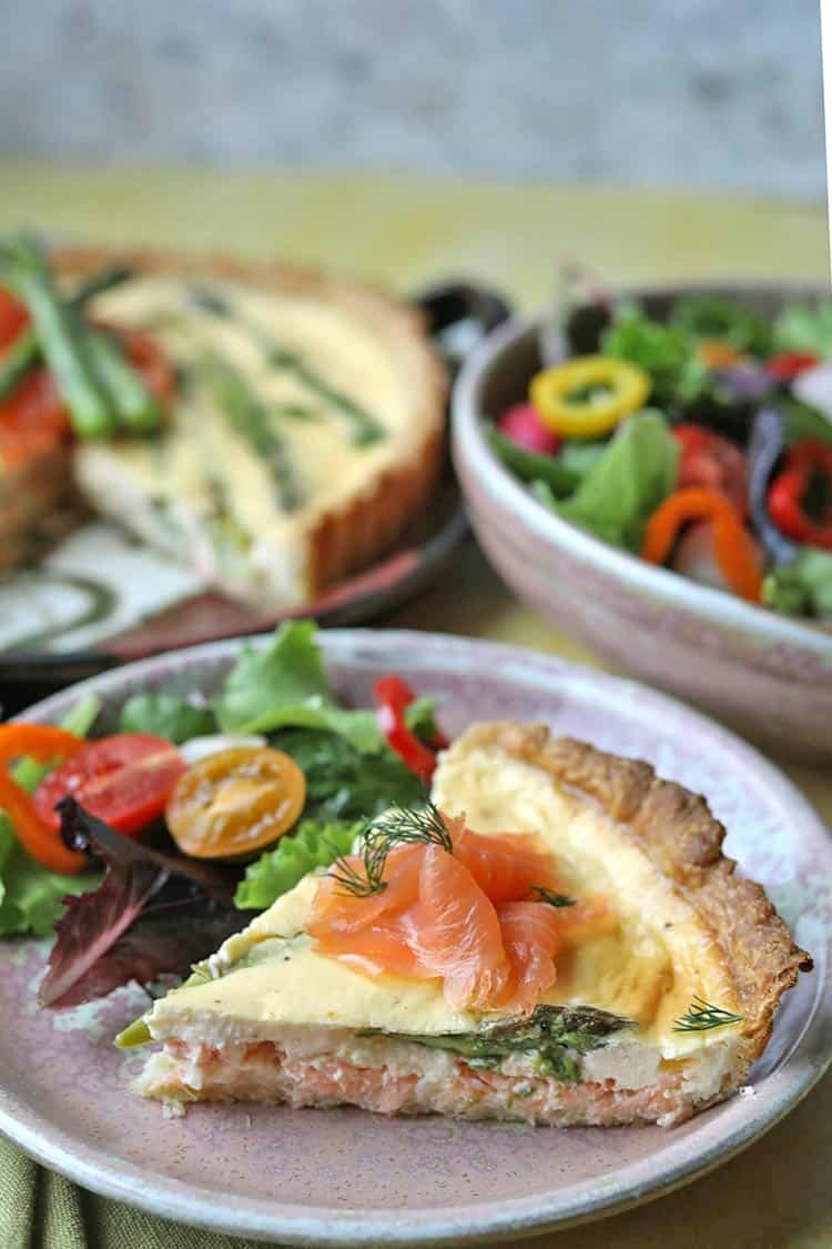 A slice of Scottish Smoked Salmon and Asparagus Tart with salad