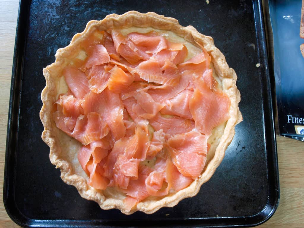 Place the smoked salmon in the base of the blind baked tart