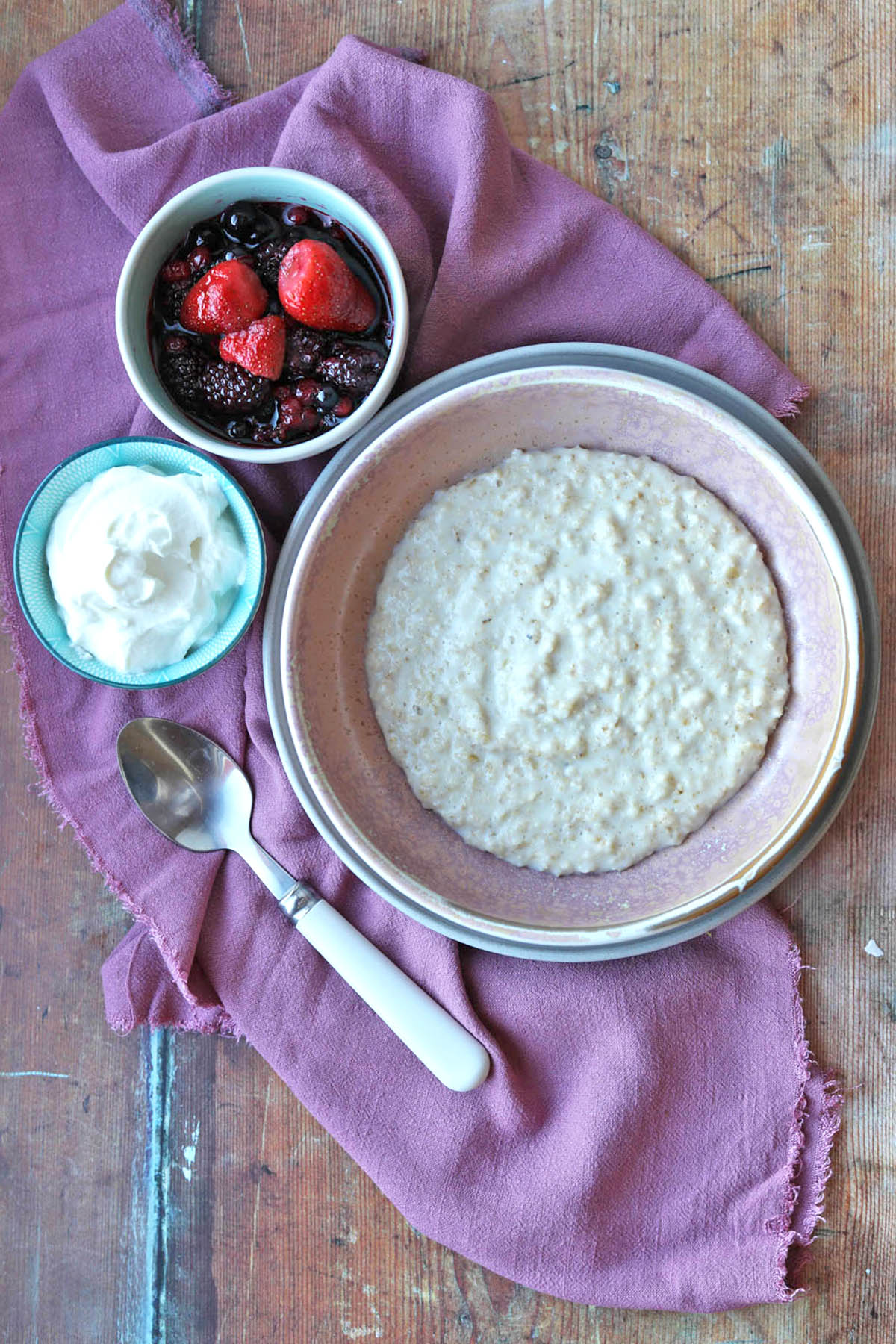 Scottish Porridge (oatmeal) in bowl with fruit and yogurt in smaller bowls