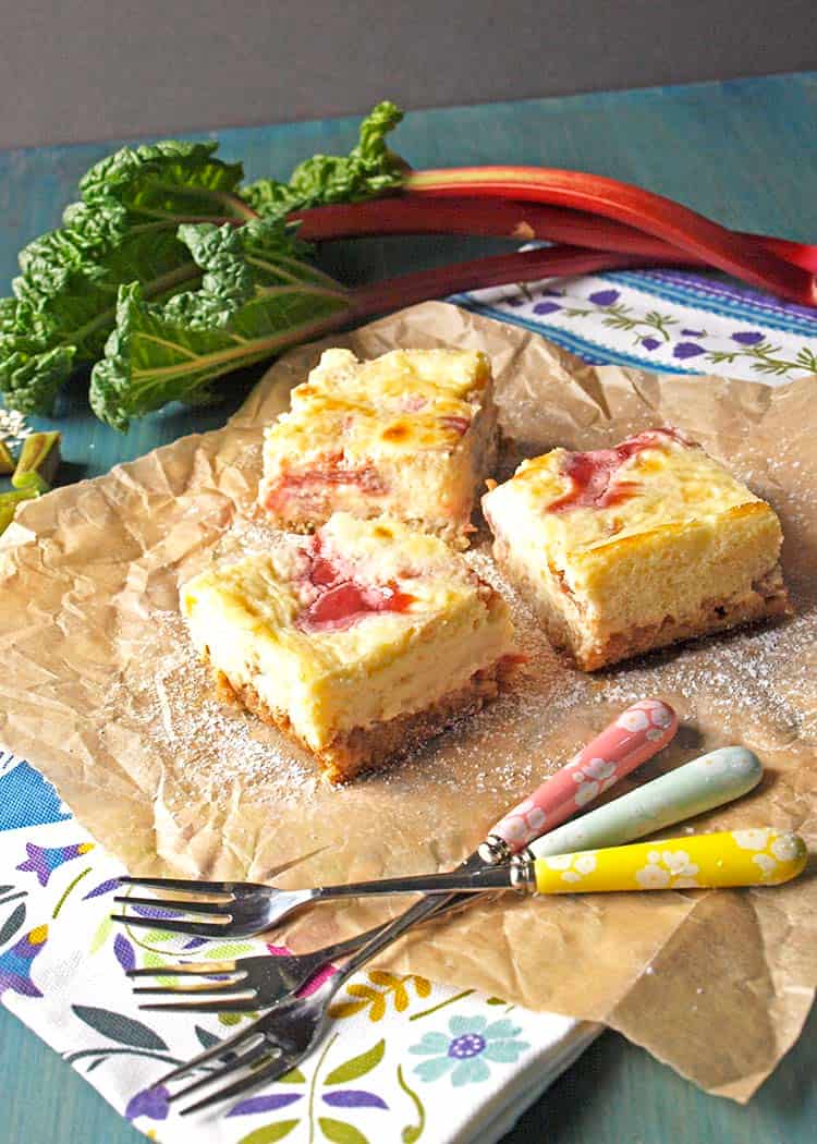 rhubarb cheesecake bars with rhubarb and forks.