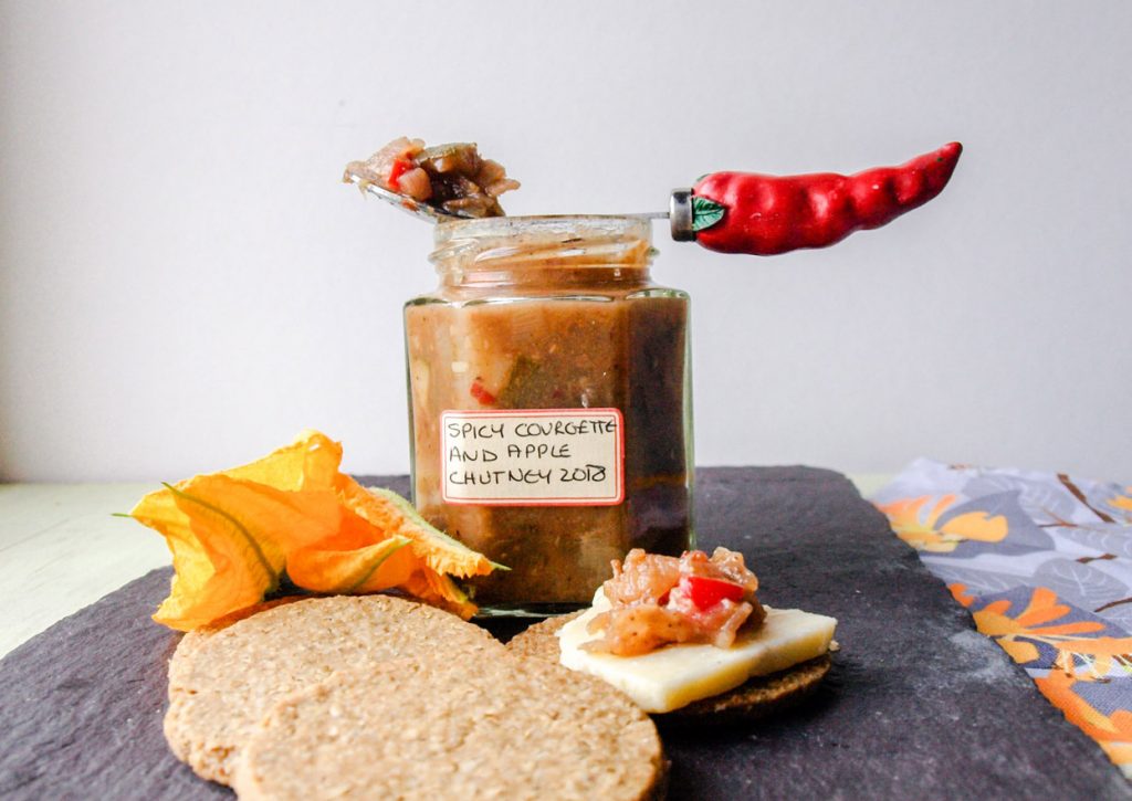 Spicy Courgette and Apple Chutney jar, spoon and oatcakes