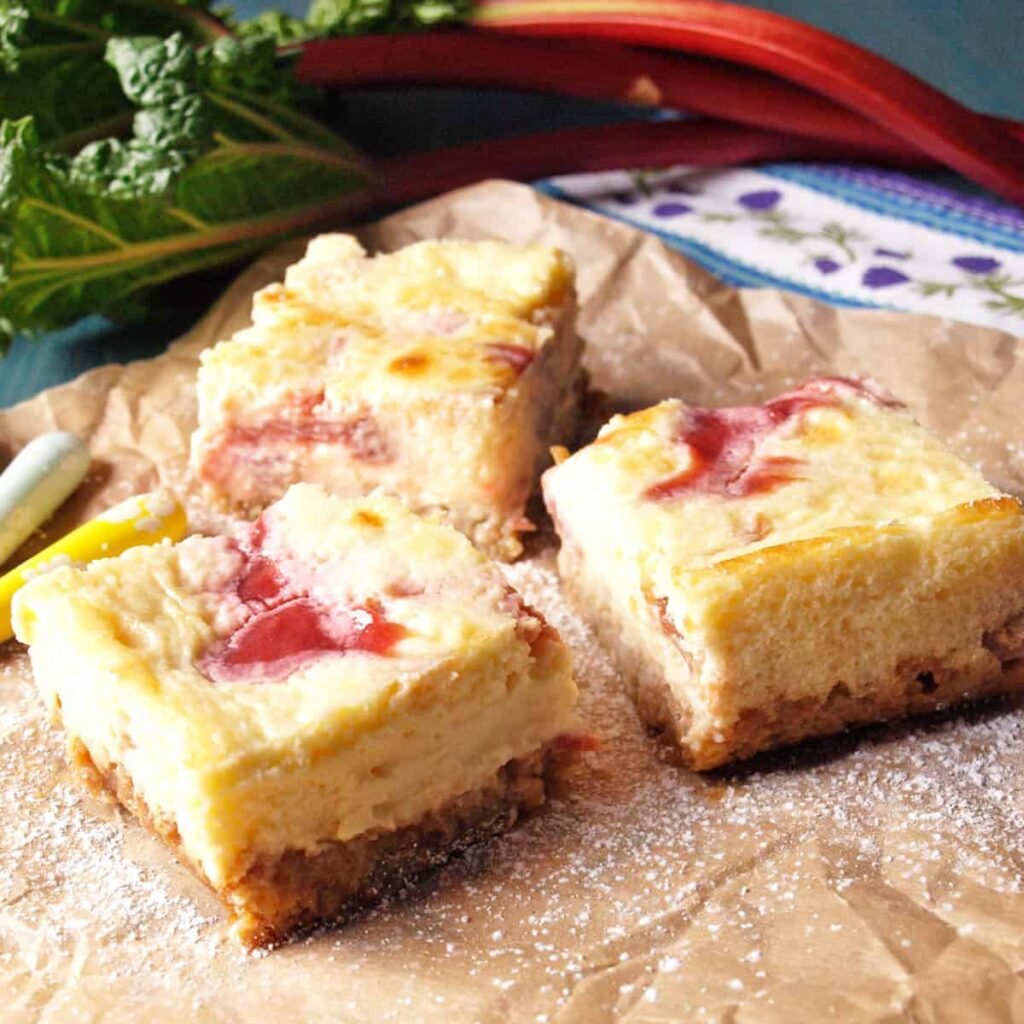 Rhubarb cheesecake bars on parchment paper
