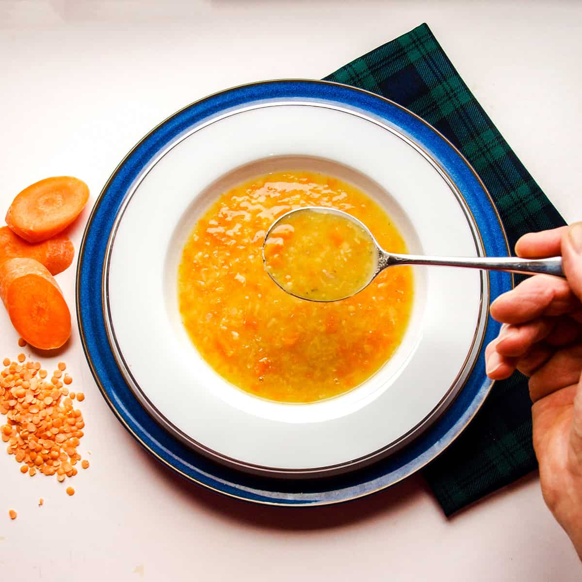 Easy Scottish Red Lentil Soup with spoon and hand