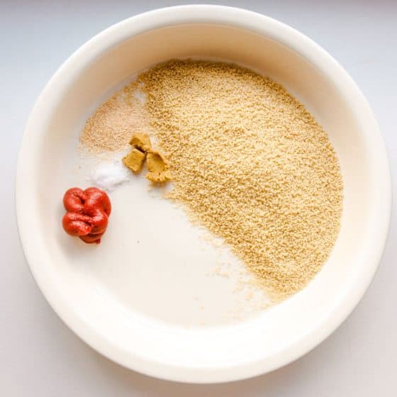 Couscous, salt, tomato puree and seasoning in bowl