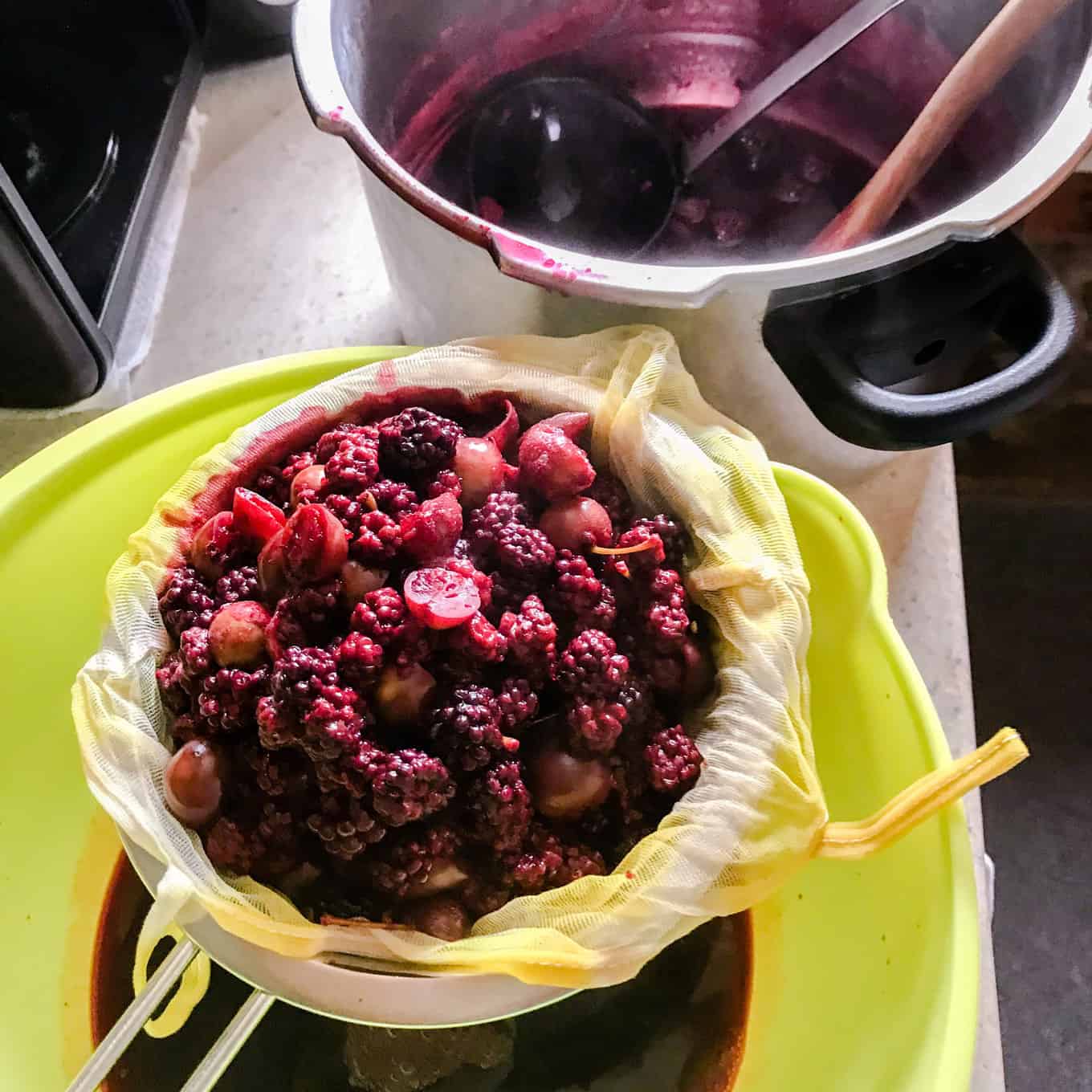 Straining juice for Blackberry and Apple Jelly through sieve and jelly bag