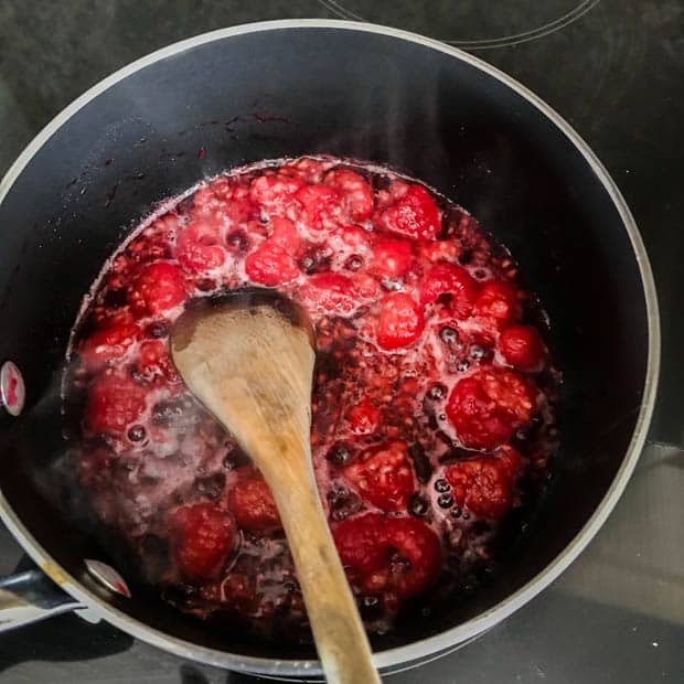 Raspberries and sugar in pan
