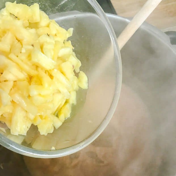 pineapple pieces going into steaming pan