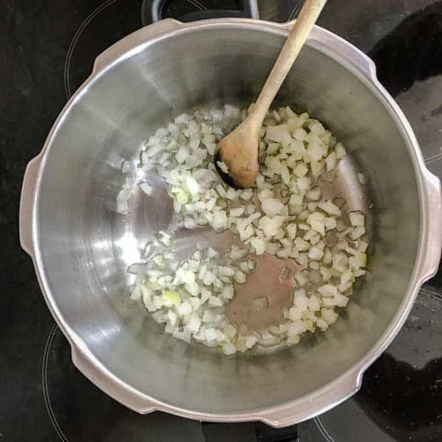 Pan with chopped onins and wooden spoon