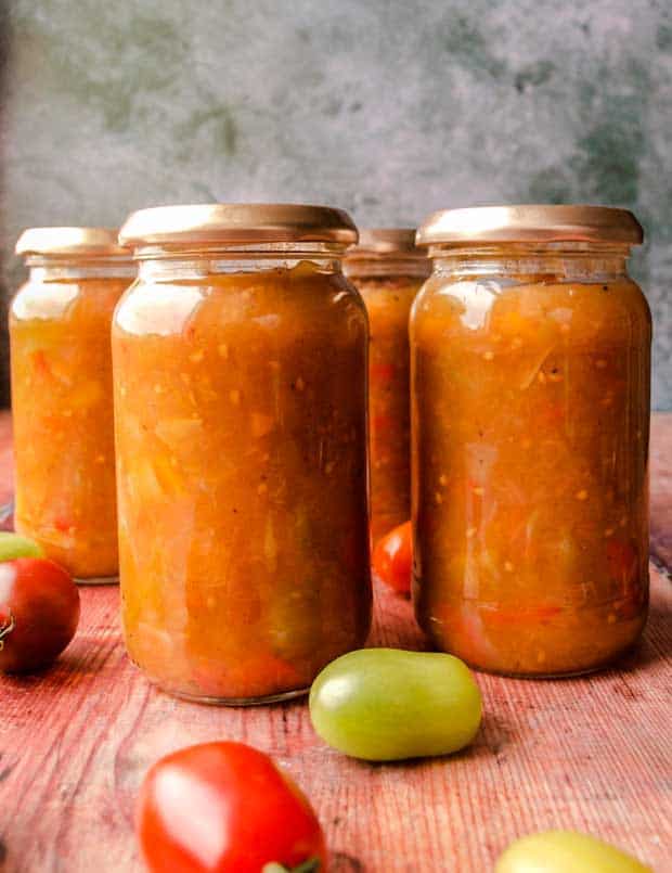 Four jars of Green Tomato, Apple & Pepper Chutney with tomatoes