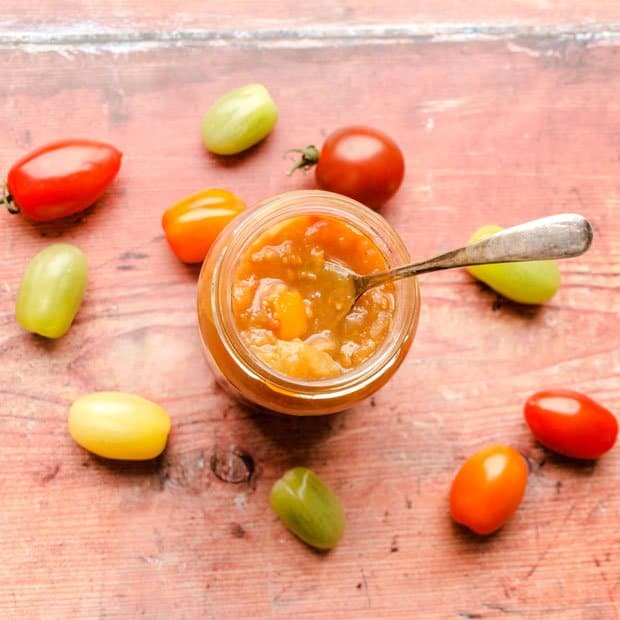 Jar of chutney with spoon and tomatoes