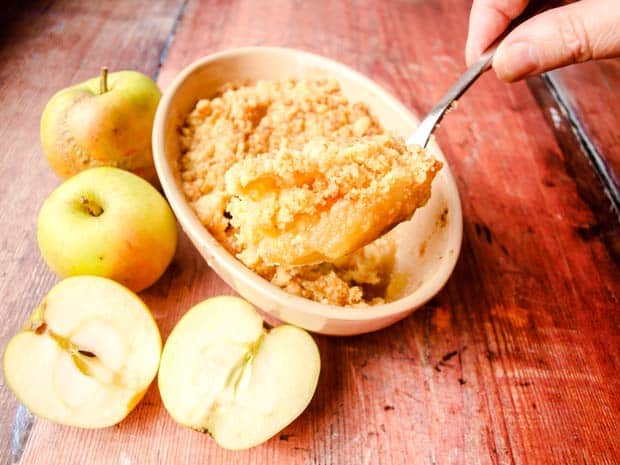 Classic Apple Crumble in baking dish with spoonful of cooked crumble and apples