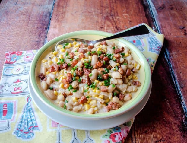 Bowl of Grilled Corn Succotash with spoon and tea towel