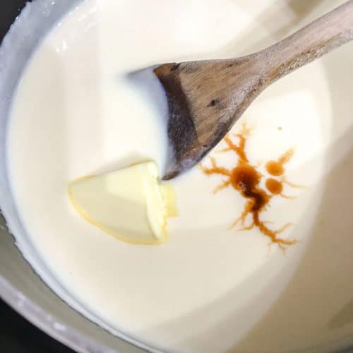 Pan of custard, with butter, vanilla extract and wooden spoon.