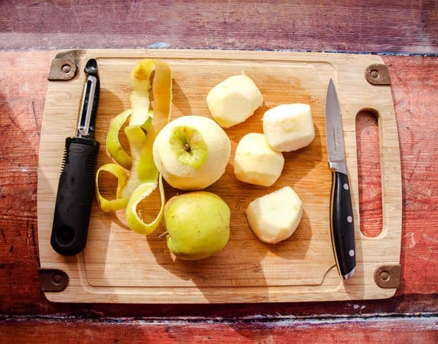 Apples peeled and cut on board with knife and peeler