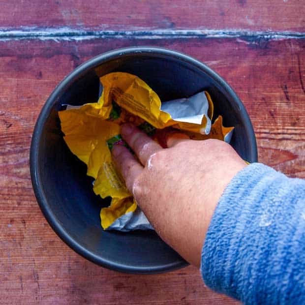 hand inside pudding basin with butter paper