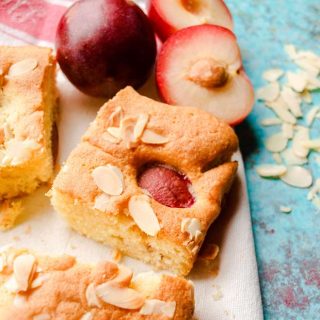 cut squares of cake with fresh plums and flaked almonds