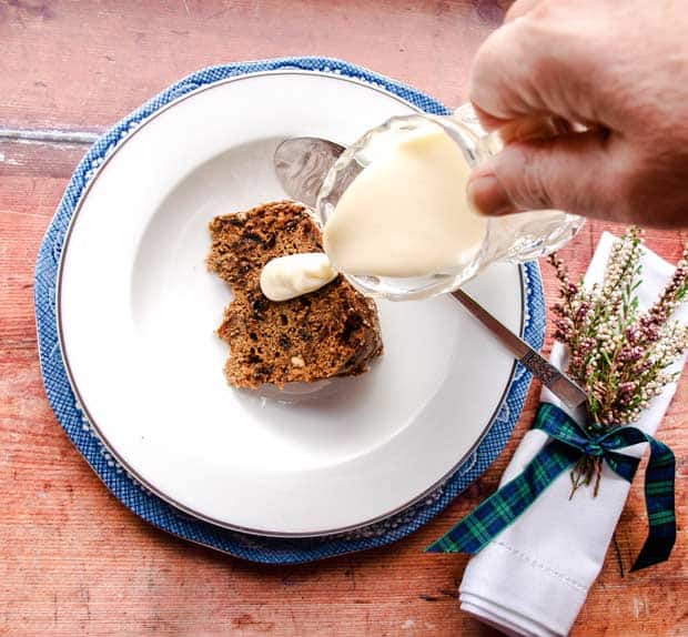 Pouring custard over dried fruit dessert. Napkin with heater on right.