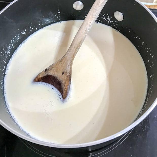 milk in pan with wooden spoon.
