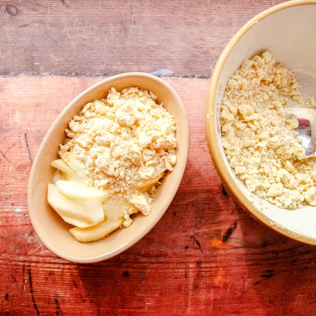 Bowl of crumble and half filled bowl of apples 