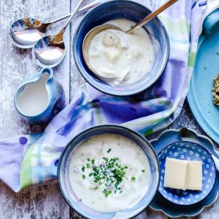 Two bowls of Scottish Cullen Skink with spoons, butter and cream in jug