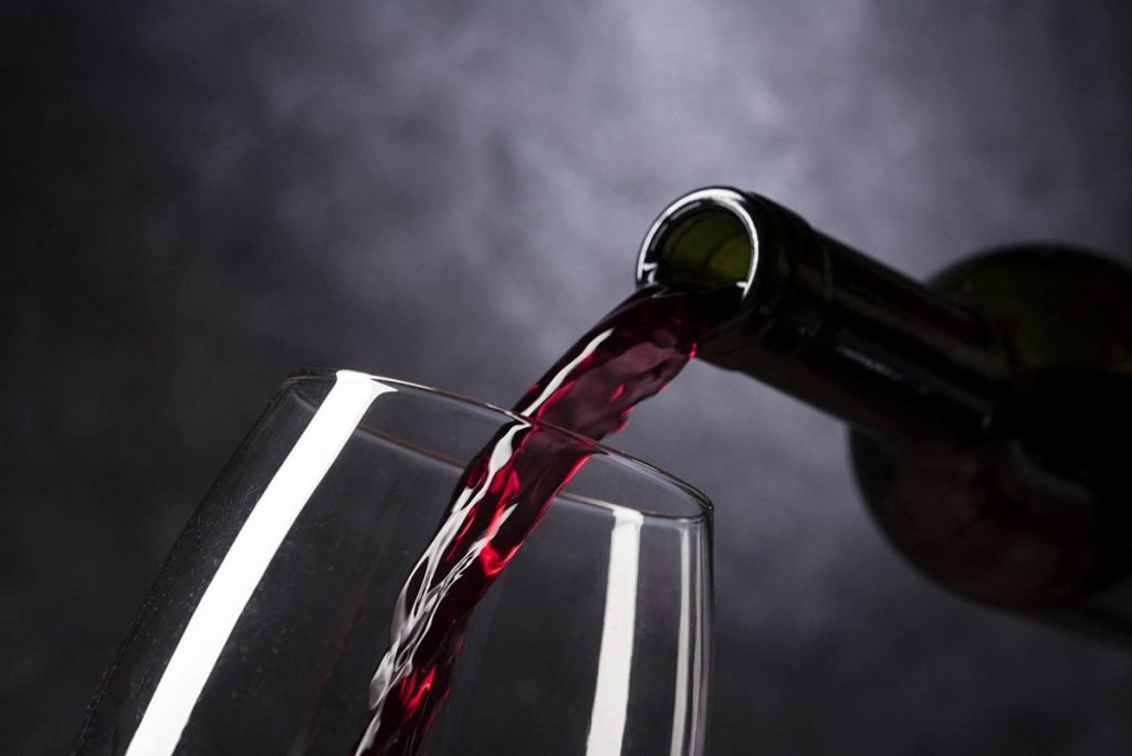 Bottle pouring red wine into glass