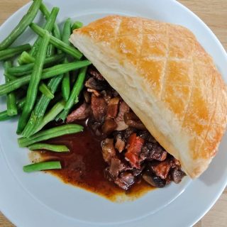 Beef Bourguignon Pie with green beans on a plate