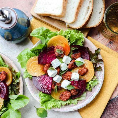 Beetroot Chorizo & Feta Salad on plate with oil pourer and slices of bread